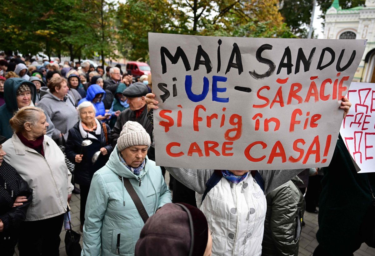 Протестующий держит плакат с надписью «Майя Санду и ЕС — нищета и холод в каждом доме» на акции протеста против Майи Санду и против присоединения Молдовы к Европейскому союзу, Кишинев, 12 октября 2024 года. Фото: Daniel Mihailescu / AFP / Scanpix / LETA