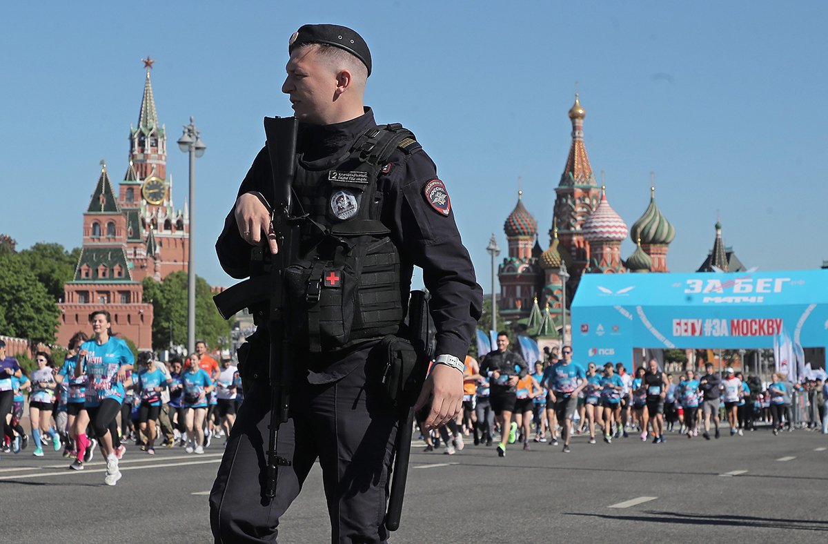 Вооруженный российский полицейский на массовом полумарафоне "Забег", у стен Кремля в Москве, Россия, 19 мая 2024. Фото: Максим Шипенков / EPA-EFE