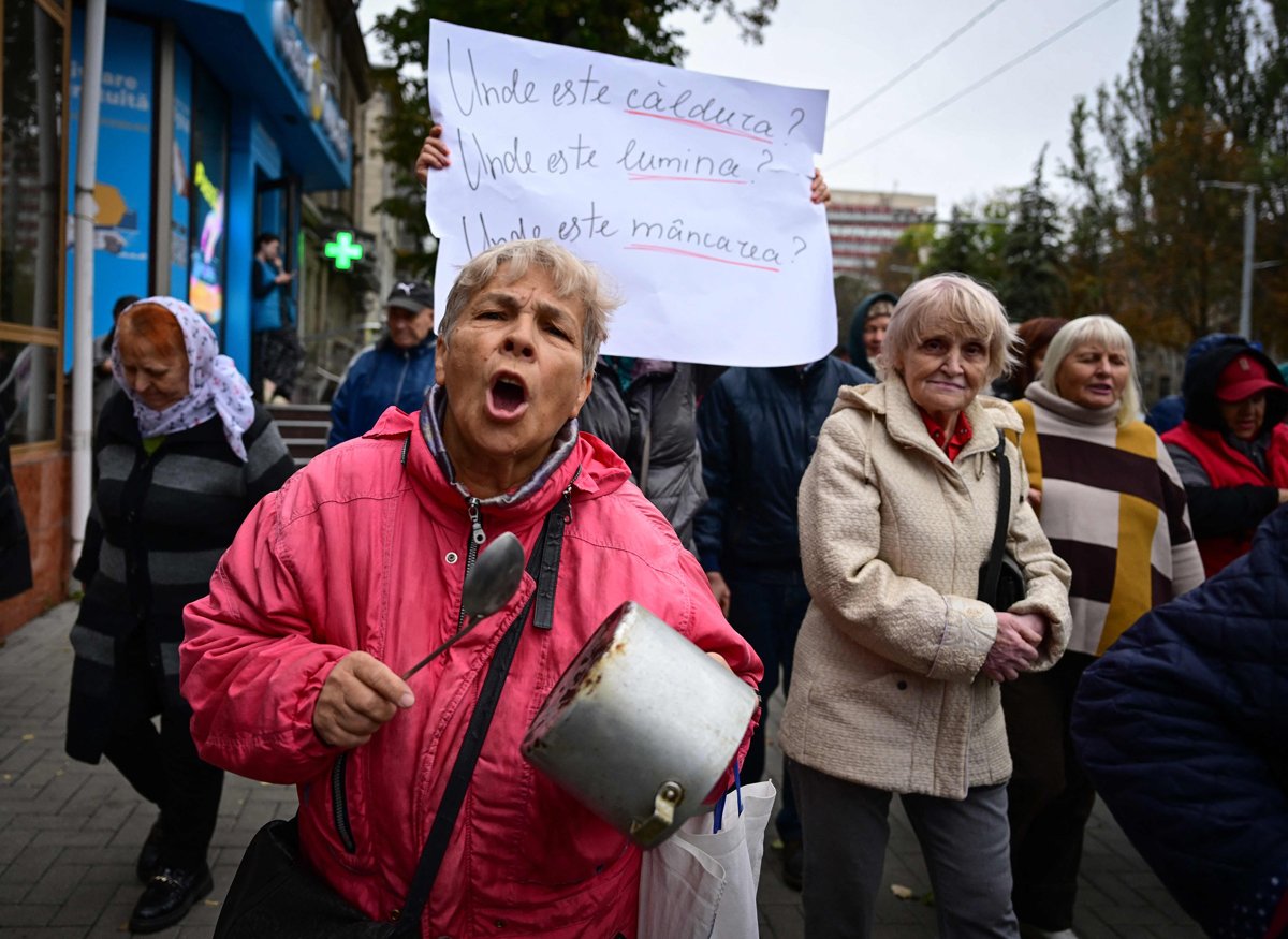 Протестующие выкрикивают лозунги и держат плакат с надписью «Где отопление, где электричество, где еда?» во время акции протеста Майи Санду в Кишиневе, 12 октября 2024 года. Фото: Daniel Mihailescu / AFP / Scanpix / LETA